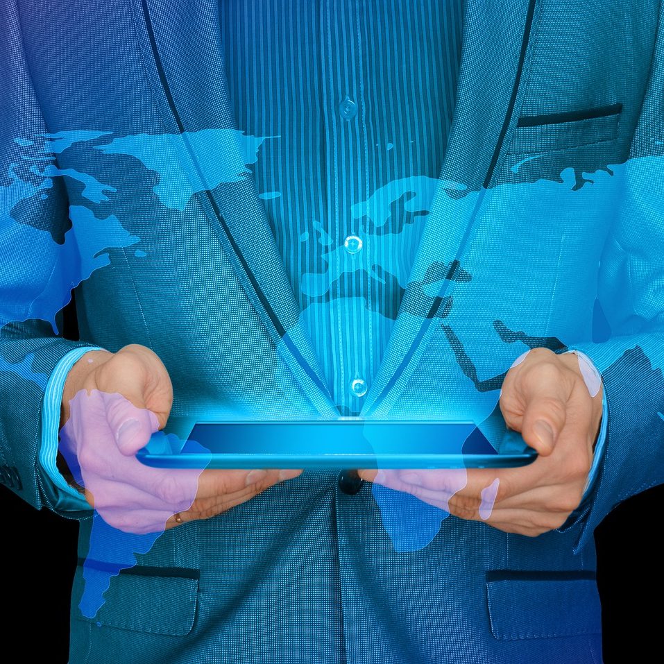 internationalisering - en man som håller i en ipad som lyser ut en karta över hela bilden