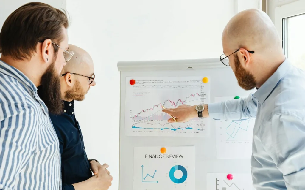 tre män analysera ekonomisk data på en tavla för att simulera Riksbanken eller experter som studerar effekten av ändringar i styrränta