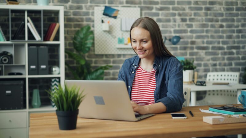 en kvinna sitter vid sin laptop och gör gri rapportering steg för steg
